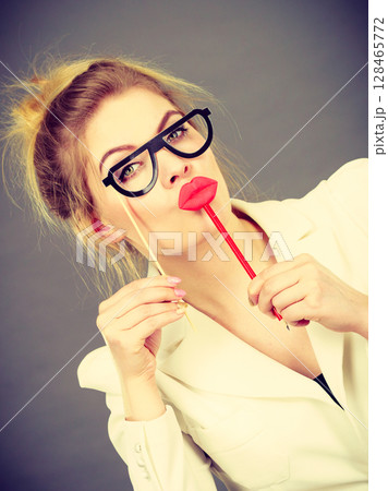 Happy elegant woman holding carnival accessoies on stick Happy elegant woman holding carnival accessoies on stick 128465772