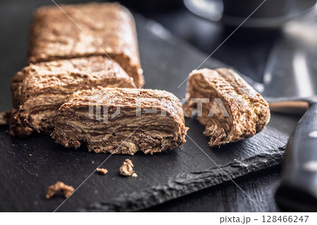 Halva with cocoa. Sweet oriental dessert on black table. 128466247