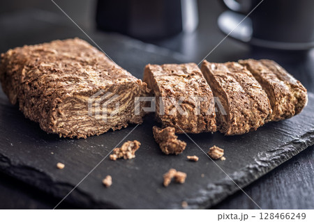 Halva with cocoa. Sweet oriental dessert on black table. 128466249
