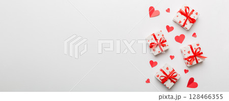 Valentine day composition: red gift box with bow and heart. Christmas present. View from above. Space for text. Holday greeting card 128466355