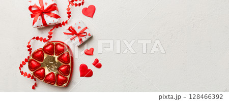 Delicious chocolate pralines in box for Valentine's Day. Heart shaped with gift box of chocolates top view with copy space 128466392