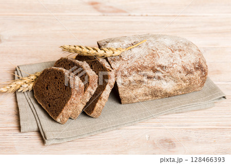 Assortment of freshly sliced baked bread with napkin on rustic table top view. Healthy unleavened bread. French bread slice 128466393