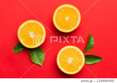 Fruit pattern of fresh orange slices on colored background. Top view. Copy Space. creative summer concept. Half of citrus in minimal flat lay Fruit pattern of fresh orange slices on colored background. Top view. Copy Space. creative summer concept. Half of citrus in minimal flat lay 128466409