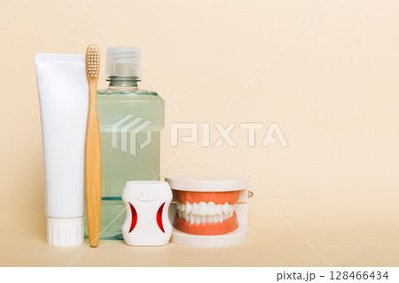 Mouthwash and other oral hygiene products on colored table top view with copy space. Flat lay. Dental hygiene. Oral care kit. Dentist concept Mouthwash and other oral hygiene products on colored table top view with copy space. Flat lay. Dental hygiene. Oral care kit. Dentist concept 128466434