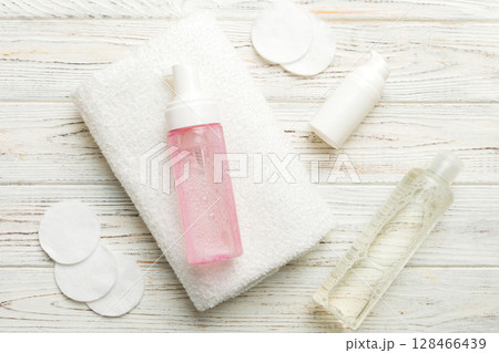 Micellar cleansing water and discs to remove cosmetics and cleanse the skin on colored background. Copy space top view Micellar cleansing water and discs to remove cosmetics and cleanse the skin on colored background. Copy space top view 128466439