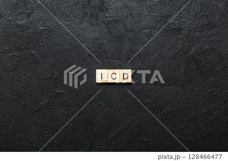 icd word written on wood block. international classification diseases text on table, concept 128466477