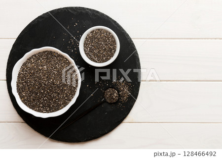 Chia seeds in bowl and spoon on colored background. Healthy Salvia hispanica in small bowl. Healthy superfood 128466492