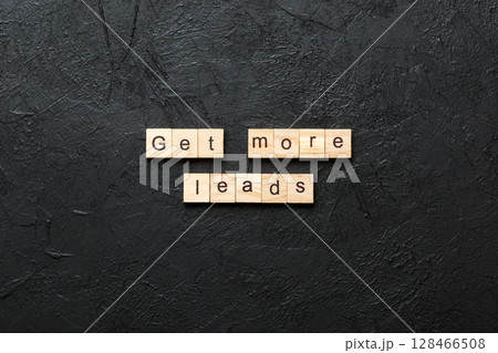 Get more leads word written on wood block. Get more leads text on table, concept 128466508