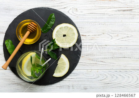 Caipirinha, Mojito cocktail, vodka or soda drink with lime, mint and straw on table background. Refreshing beverage with mint and lime in glass top view flat lay 128466567