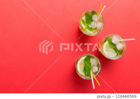 Caipirinha, Mojito cocktail, vodka or soda drink with lime, mint and straw on table background. Refreshing beverage with mint and lime in glass top view flat lay 128466569