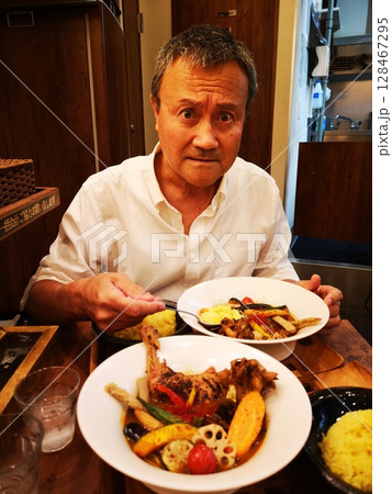 スープカレーを食べるシニア男性 128467295