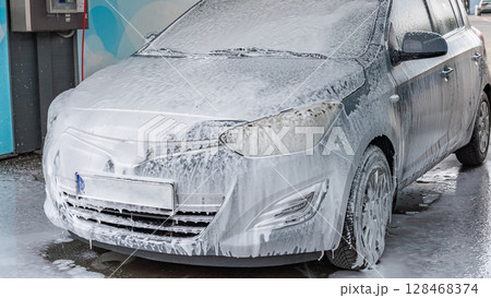 Car wash. Car cleaning foam soap bubbles. Spray water vehicle shine wet. 128468374