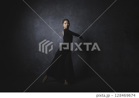 黒背景でポーズをとる女性　　 128469674
