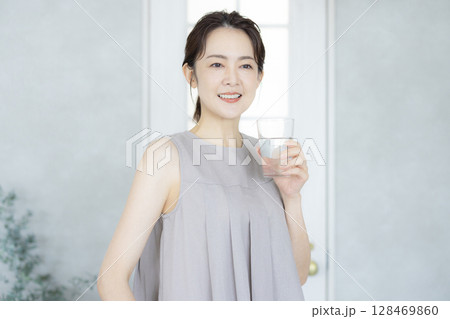 キッチンで水を飲むミドルの女性 キッチンで水を飲むミドルの女性 128469860