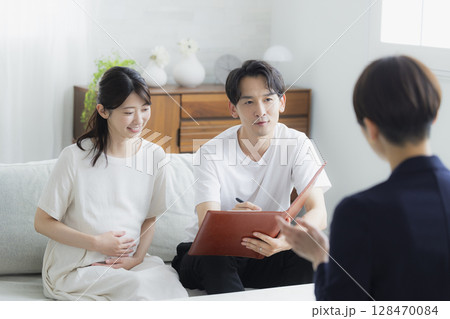 スーツの女性に相談する夫婦 128470084
