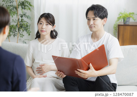 スーツの女性に相談する夫婦 128470087