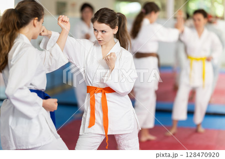Women in sparring work out the technique of blows 128470920