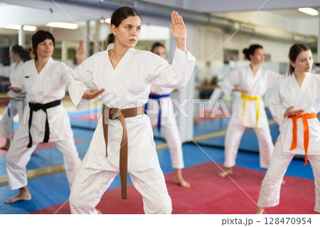 Women in self-defense training in white kimono with belts 128470954