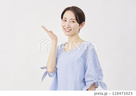 女性 ミドルエイジ 手のひらで左を指す 白背景 女性 ミドルエイジ 手のひらで左を指す 白背景 128471023