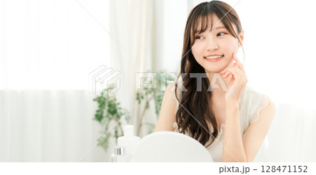 基礎化粧品・コスメで保湿・スキンケア・アンチエイジングをする若いアジア人女性 128471152