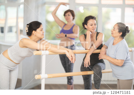 Women communicate with each other during a break between classes in choreographic studio Women communicate with each other during a break between classes in choreographic studio 128471181