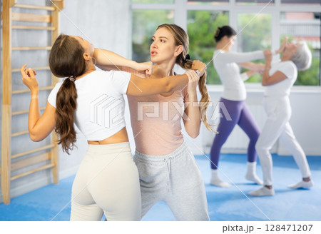 Two young women training self-defense techniques 128471207