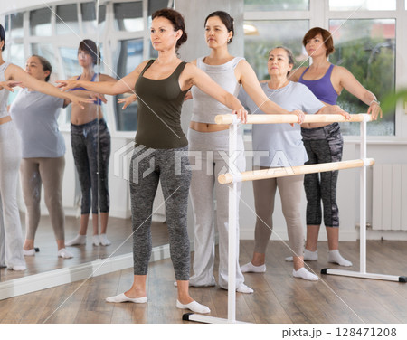 Female ballet instructor leading rehearsal with group of amateur women 128471208
