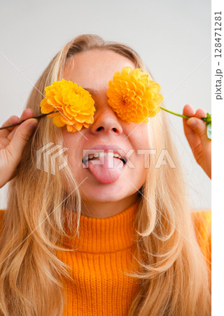 Woman in yellow sweater close her eyes with yellow dahlia Selective focus Bush of autumnal orange red chrysanthemums and violet dahlia hydrangea. Fall garden beautiful flowers bouquet background Woman in yellow sweater close her eyes with yellow dahlia Selective focus Bush of autumnal orange red chrysanthemums and violet dahlia hydrangea. Fall garden beautiful flowers bouquet background 128471281