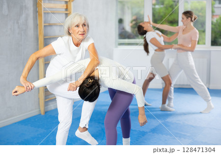 Young and elderly women training self-defense techniques Young and elderly women training self-defense techniques 128471304