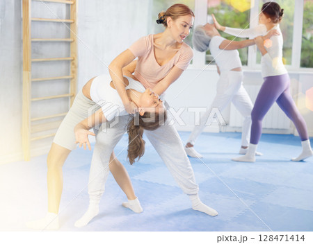 Two young women training self-defense techniques 128471414