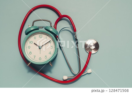 Teal Alarm Clock and Red Stethoscope on Light Blue Background - Time for Health Check 128471508