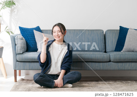 リビングでくつろぐ若い女性 リビングでくつろぐ若い女性 128471625