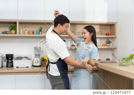 Couple Dancing in Kitchen. Celebrating love and joy through movement. Couple Dancing in Kitchen. Celebrating love and joy through movement. 128471977