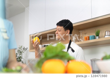 Healthy Lifestyle: Man Holding Fresh Yellow Bell Pepper in Kitchen Healthy Lifestyle: Man Holding Fresh Yellow Bell Pepper in Kitchen 128471980
