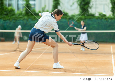 Girl plays tennis on open court with opponent Girl plays tennis on open court with opponent 128472373
