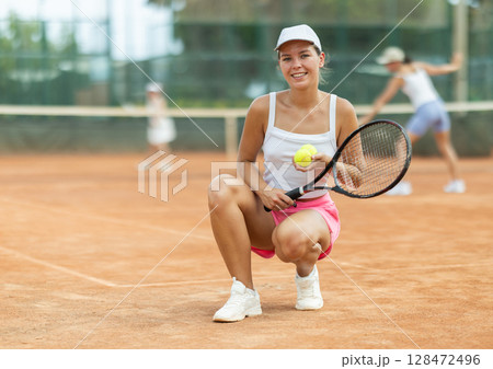 Portrait of sporty woman tennis player with racket and ball in hands Portrait of sporty woman tennis player with racket and ball in hands 128472496
