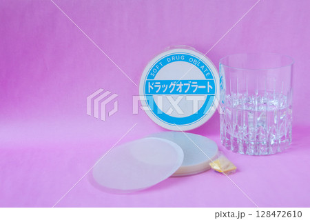 薬用オブラートと水の入ったコップとオブラートで包んだ粉薬 薬用オブラートと水の入ったコップとオブラートで包んだ粉薬 128472610