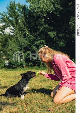 Woman spending quality time with her pet playing Badminton shuttlecock on green grass. Outside recreation and fresh air summertime. Healthy lifestyle nature connection sport summer activities. Stress Woman spending quality time with her pet playing Badminton shuttlecock on green grass. Outside recreation and fresh air summertime. Healthy lifestyle nature connection sport summer activities. Stress 128472691