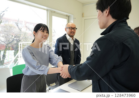 名刺交換をするエンジニアとビジネスウーマン 名刺交換をするエンジニアとビジネスウーマン 128473960