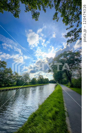 A Peaceful and Serene River Pathway Stretching Out Set Against a Stunning and Expansive Sky A Peaceful and Serene River Pathway Stretching Out Set Against a Stunning and Expansive Sky 128474316