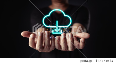 Data at your fingertips. Cloud computing is visualized with a glowing download icon above cupped hands, representing easy access and connectivity. Data at your fingertips. Cloud computing is visualized with a glowing download icon above cupped hands, representing easy access and connectivity. 128474613