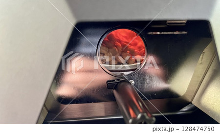 Close up coffee machine with coffee beans and magnifying glass Close up coffee machine with coffee beans and magnifying glass 128474750