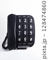 Black analog desk or wall telephone and handset receiver with curly cord on white background. 128474860
