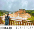 登別地獄谷で両手を広げて大自然を感じる女性 128474987