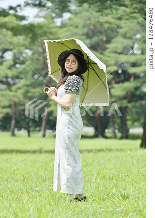 日傘をさして散歩する若い女性 日傘をさして散歩する若い女性 128476480