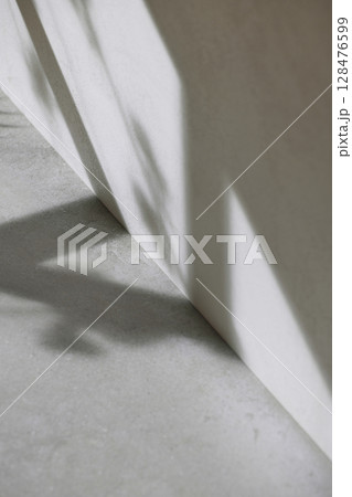Concrete texture background with shadows from natural light streaming through a window. Concrete texture background with shadows from natural light streaming through a window. 128476599