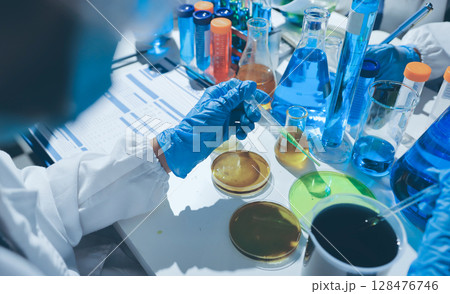 Scientist pipetting medical samples into microplate in laboratory Scientist pipetting medical samples into microplate in laboratory 128476746
