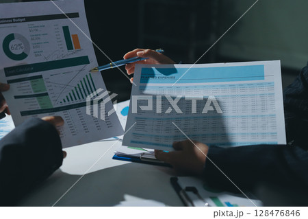 Group of business women working on a financial data expenses document. Group of business women working on a financial data expenses document. 128476846