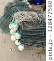 Pile of Fishing Traps with Buoys on Sandy Ground. 128477560