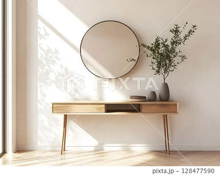 A modern entryway with a minimalist console table, a round mirror on the wall and small plant in a vase on the table.  128477590